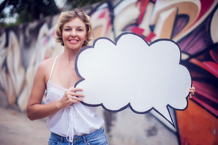Young woman holding a speech bubble on a colorfull background