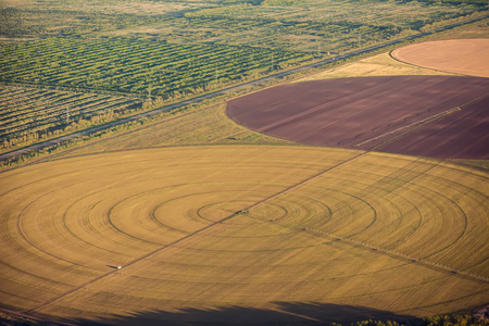 Automatic sprinklering system of a cultivated field.Central pivot irrigation system. The view from the airplane.の写真素材