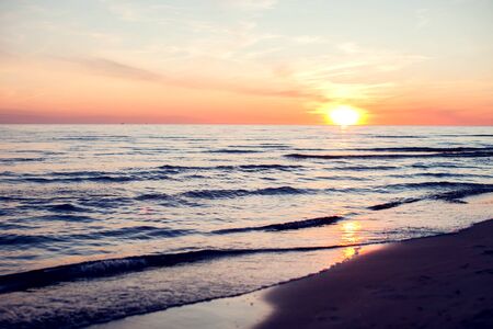 A sunset on the beach in summer. Sea and eveninig sky with cloudsの写真素材