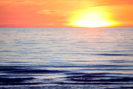 A sunset on the beach in summer. Sea and eveninig sky with cloudsの写真素材