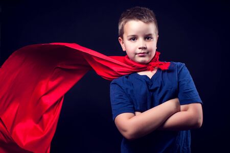 A cute boy with red cloak like a superhero. Children and success conceptの写真素材