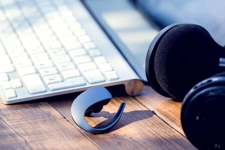 Headphones and laptop are on the wooden table outdoor. Technology and lifestyle conceptの写真素材