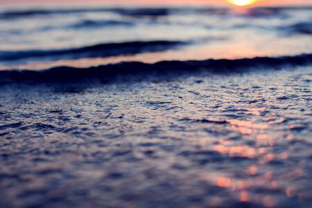 A sunset on the beach in summer. Sea and eveninig sky with clouds