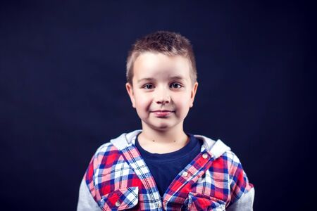 A portrait of a cute smilling boy on the black backgroundの写真素材