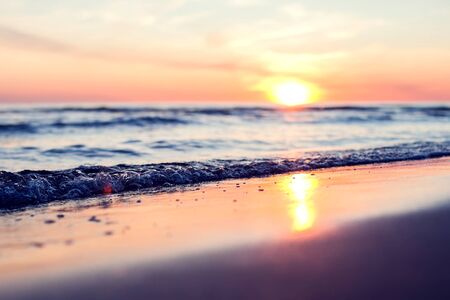 A sunset on the beach in summer. Sea and eveninig sky with clouds