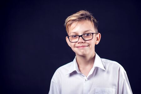 A portrait of a cute smilling boy on the black backgroundの写真素材
