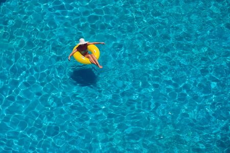 Woman swims on the inflatable circle in the pool. Up view. Summer and holiday conceptの写真素材