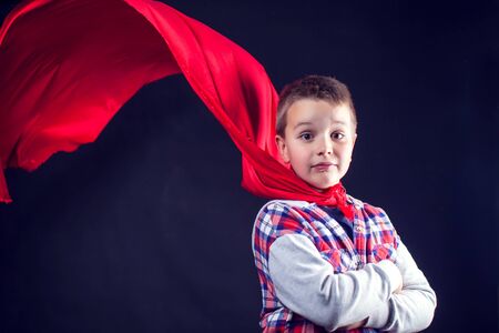A cute boy with red cloak like a superhero. Children and success conceptの写真素材