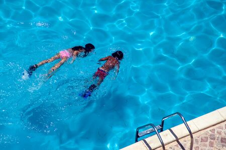 Children swim in the pool. Up view. Summer and vacation conceptの写真素材
