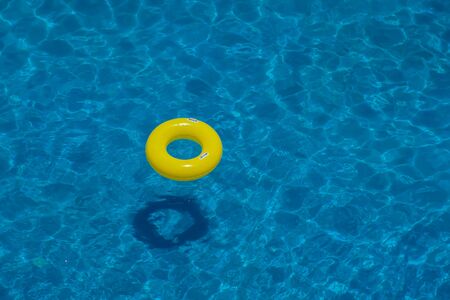 Yellow inflatable circle in the swimming pool. Up view. Summer and holiday concept