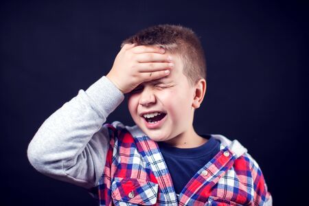 A boy feels strong headache. Children, healthcare and medicine conceptの写真素材