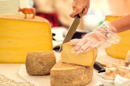 Seller prepare cheese for the custumers at cheese festival. Organic and farm food conceptの写真素材