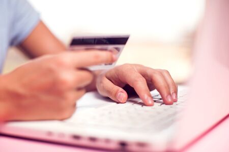 Woman holds credit card and makes online payment with laptop. Online shopping concept