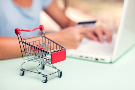 Woman holds credit card and makes online payment with laptop. Online shopping conceptの写真素材