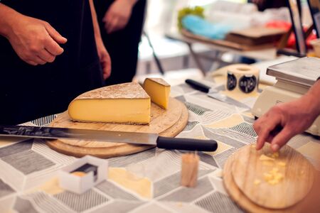 Seller prepare cheese for the custumers at cheese festival. Organic and farm food conceptの写真素材