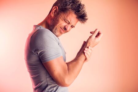 Man feels strong pain in elbow. People, healthcare and medicine conceptの写真素材