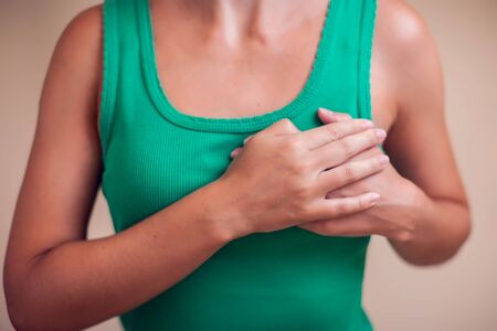 Woman with short hair feels strong heart pain isolated. People, healthcare and medicine conceptの写真素材