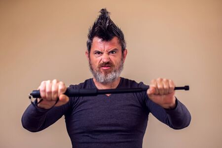 Bearded angry man with tonfa. People and emotions concept