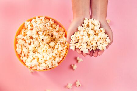 A bowl with popcorn on pink background. Food and entertaiment conceptの写真素材