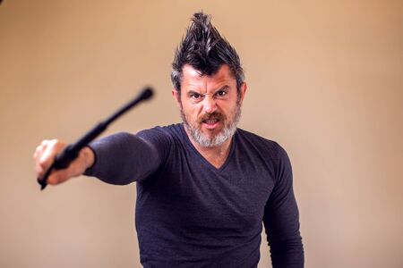 Bearded angry man with tonfa. People and emotions concept