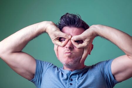 Funny man making finger mask hero. Heroic mood of super man. People, emotions and lifestyleの写真素材