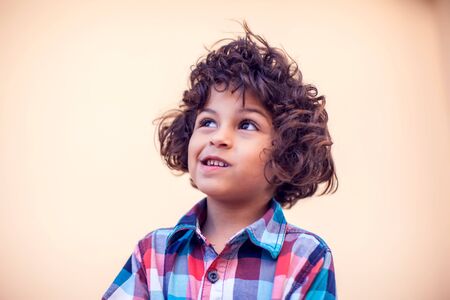 Little boy with curly hair thinking about something. Children and emotions conceptの写真素材