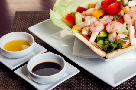 Sea food salad with sauces on white plate.の写真素材