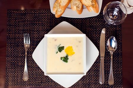 Cream soup and bread croutons on the table in cafe