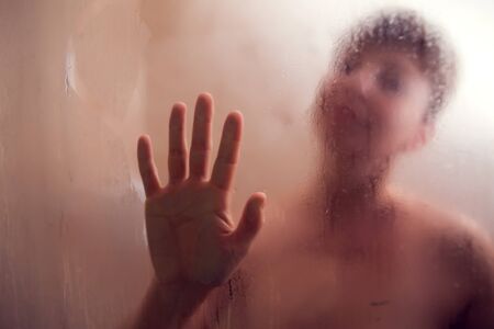 Woman's Hand Held Up Against Steamed Glass. Palm on the moisture mirrorの写真素材
