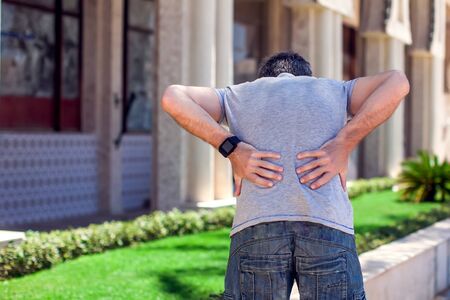 Man with back pain at the street. People, health care, medicine conceptの写真素材