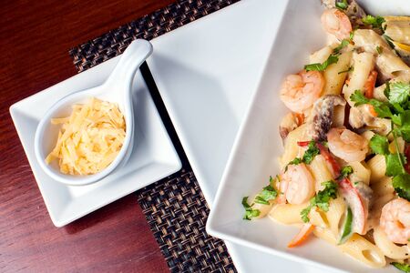 Penne (pasta) with shrimps/prawns and sausage in pomodoro (tomato) sauce - Italian cuisine, cooking, culinary (traditional authentic taste).の写真素材