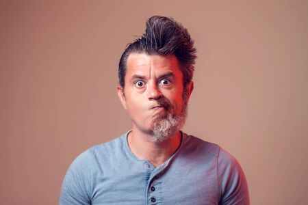 A portrait of man with half beard and hair on brown backgroundの写真素材