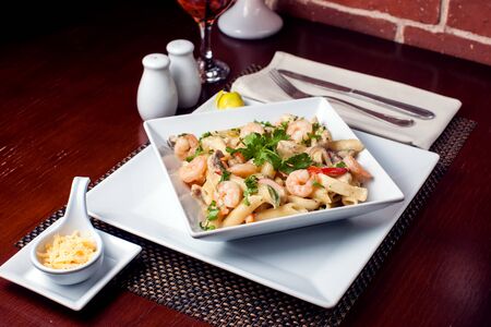 Penne (pasta) with shrimps/prawns and sausage in pomodoro (tomato) sauce - Italian cuisine, cooking, culinary (traditional authentic taste).の写真素材