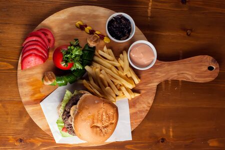 Large tasty burger with mushrooms with French fries.の写真素材