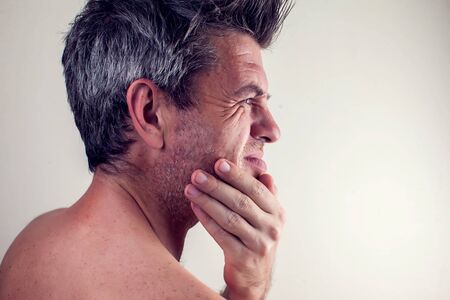 Man feels strong tooth pain. People, healthcare and medicine concept.の写真素材