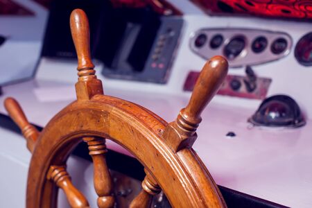 Wooden steering wheel and control panel on a yacht.の写真素材