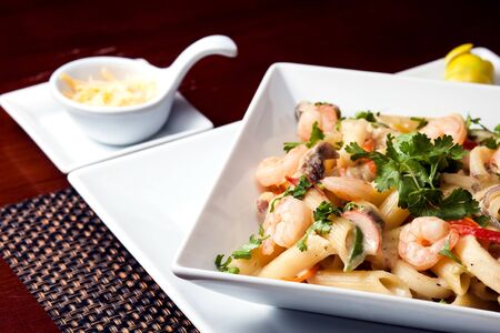 Penne (pasta) with shrimps/prawns and sausage in pomodoro (tomato) sauce - Italian cuisine, cooking, culinary (traditional authentic taste).の写真素材