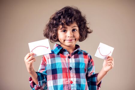 Kid boy select between positive and negative expressions. Children and emotions conceptの写真素材