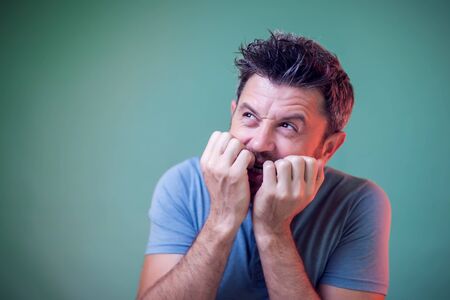 People and emotions - a portrait of nervous man with beard nail bittingの写真素材