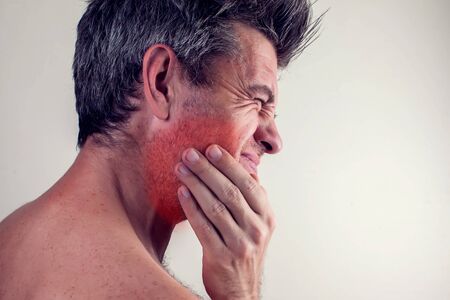 Man feels strong tooth pain. People, healthcare and medicine concept.の写真素材