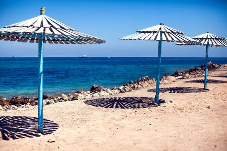 Sun umbrellas on a beach with sea background. Summer, vacation concept