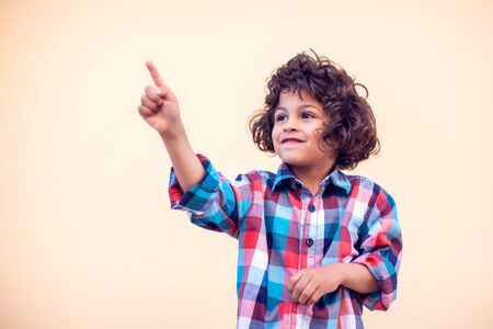 Arab boy pointing his finger with a smile on his face