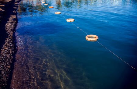 Protective buoys on sea surface. Fencing on water. Save zone for swimming