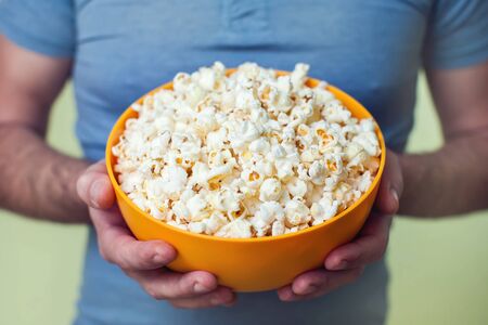 Hands holding a popcorn box. People and food conceptの写真素材