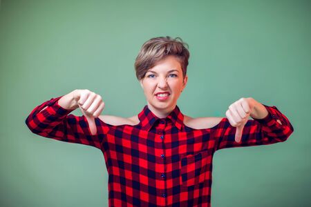 People and emotions - a portrait of happy young woman showing thumbs down gestureの写真素材