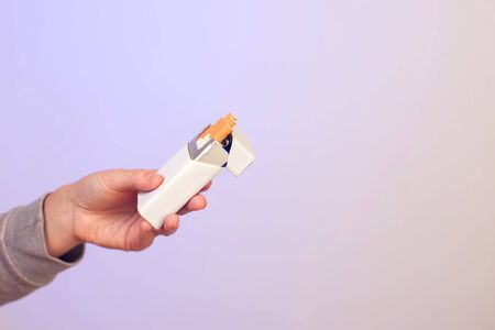 Closeup Of Male Hand Holding Cigarettes Pack. People, Healthcare And Smoking Concept.の写真素材