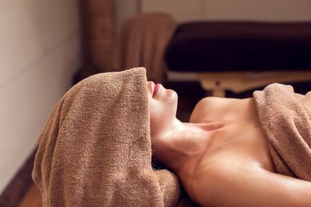 Beautiful young woman relaxing in the spa salon-Spa, beauty, people and body care conceptの写真素材