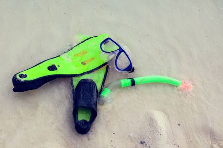 Summertime and holiday concept. Beach view. Diving mask and flippers lelft on beachの写真素材