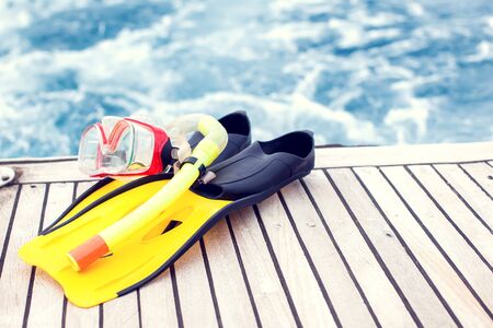 Summertime and vacation concept. Sea view. Diving mask and flippers lelft on boat.の写真素材