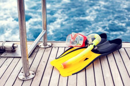 Summertime concept. Sea view. Diving mask and flippers lelft on boat.の写真素材